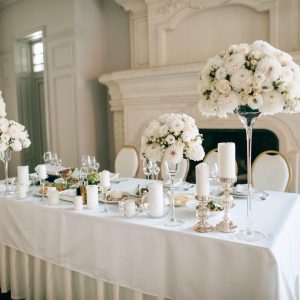 Table decor with white flowers and candles for an event party or wedding reception